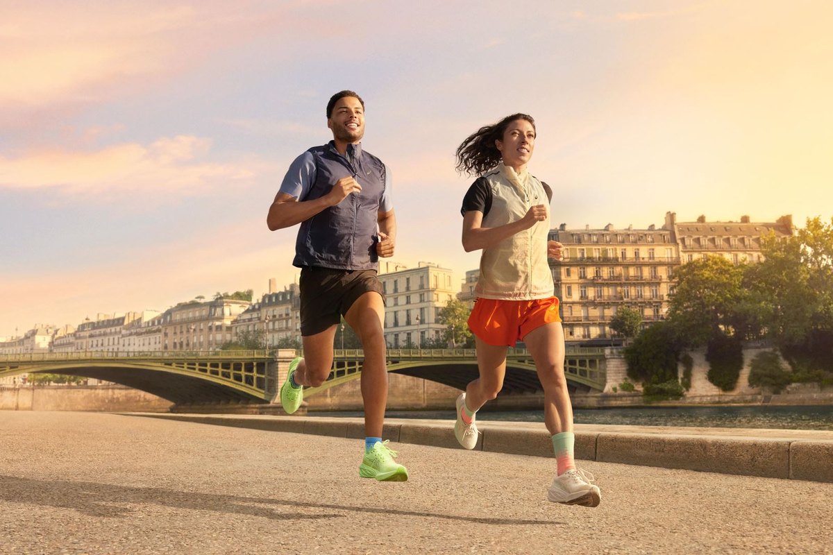 Двама бегачи с обувки Asics пресичат мост в Париж на разсъмване