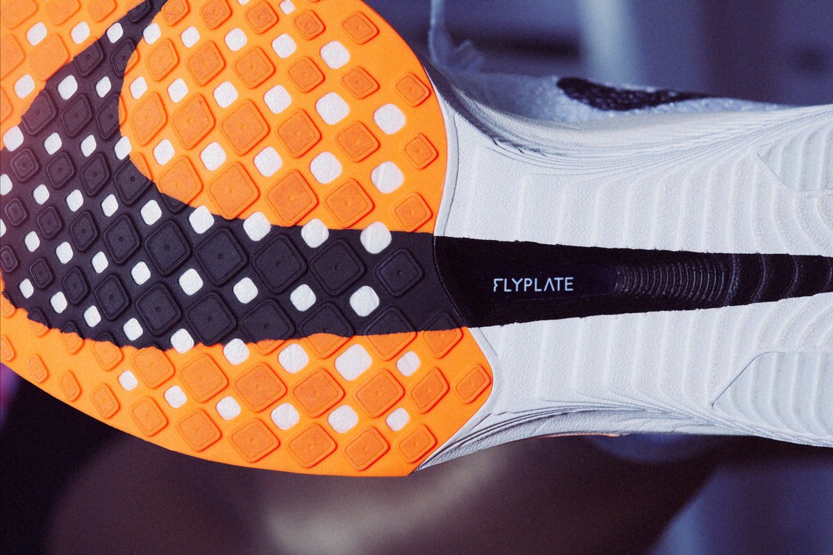 Подметката на Nike Vaporfly 3 отдолу: оранжева гума и черно прозорче в междинната подметка, през което се вижда карбоновата пластина с надпис Flyplate